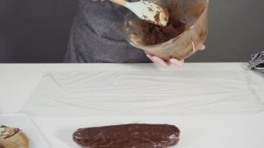 Tahta kesme tahtasıyla çikolatalı kurabiye hamuru kesmek.