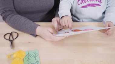 Küçük kız dikiş setiyle dikiş dikmeyi öğreniyor..