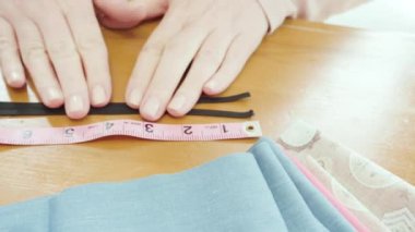Koronavirüs salgını için dikiş makinesiyle pamuk yüz maskesi dikiyorum..
