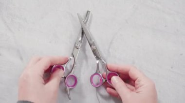 Gri arkaplanda yeni berber pembe makas.