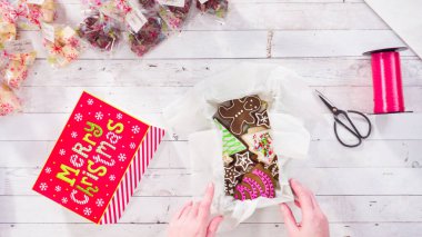 Düz yatıyordu. Adım adım. Ev yapımı şekerleme ve kurabiyeleri Noel hediyesi kutusuna koymak.