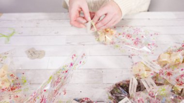 Adım adım. Ev yapımı şekerleme paketleri küçük hediye paketlerine konuyor..