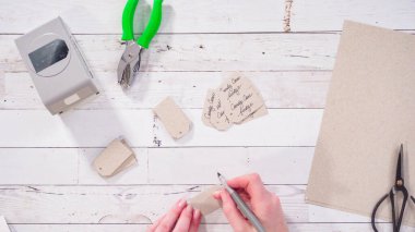 Düz yatıyordu. Adım adım. Siyah işaretli kahverengi kağıt hediye etiketleri.