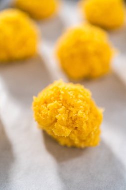 Beyaz çikolatalı limonlu kurabiye. Beyaz çikolatalı limonlu kurabiye pişirmek için parşömen kağıdıyla kaplı bir yemek tepsisine hamur kepçesiyle kurabiye pişirmek..