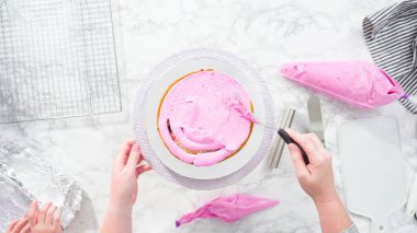 Düz yatıyordu. Adım adım. Pembe tereyağlı krema kaplı yuvarlak funfetti kek katmanları.