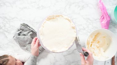 Düz yatıyordu. Adım adım. Beyaz İtalyan kremalı, yuvarlak funfetti keki..