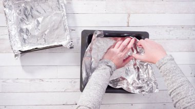 Düz yatıyordu. Adım adım. Ev yapımı şekerleme yapmak için pişirme kabını folyoyla kaplıyorum..