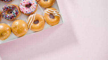 Düz yatıyordu. Beyaz bir karton kutuda mağazadan alınmış donutların çeşitliliği.