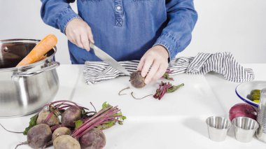 Adım adım. Sirkeli salata için beyaz bir kesme tahtasındaki sebzeleri dilimliyorum..