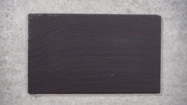Empty large slate serving board on the counter.