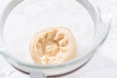 Büyük bir bardaktaki malzemeleri karıştırıyorum. Pizza hamuruyla karıştırıyorum..