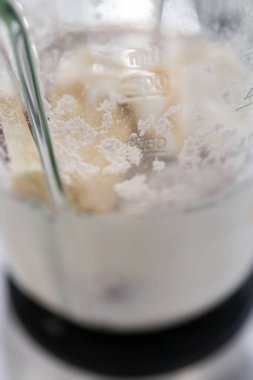 Mutfak blendırında sağlıklı kahvaltı için muz suyu karışımı karışımı..