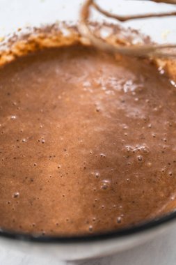 Kırmızı kadife kek ve krem peynir jöleli kek yapmak için büyük bir bardakta karıştırma malzemesi..