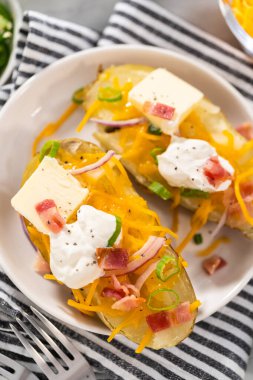 Fırında pişmiş patates. Tereyağı, ekşi krema, peynir ve pastırma parçalarıyla süslenmiş büyük fırında patates..