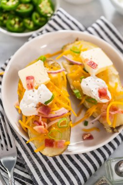 Fırında pişmiş patates. Tereyağı, ekşi krema, peynir ve pastırma parçalarıyla süslenmiş büyük fırında patates..