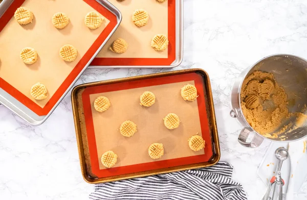 Flat lay. Placing a peanut butter cookie dough on silicone mats for baking.