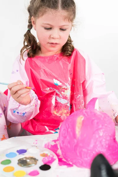 小女孩用丙烯酸粉刷万圣节南瓜 — 图库照片