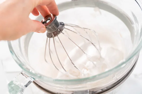 Making meringue in kitchen mixer to bake unicorn meringue cookies.