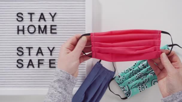 Stay Home Schild Auf Der Anzeigetafel Mit Einer Hausgemachten Gesichtsmaske — Stockvideo
