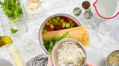 Düz yatıyordu. Adım adım. Maden işlemeli, dökme demir bir fırında makarna tarifi pişiriyorum..