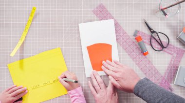 Düz yatıyordu. İnşaat kağıdından el yapımı Babalar Günü kartı yapan küçük bir kız..