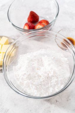 Çilekli tereyağlı kremayı hazırlamak için bardaktaki karışımlar..