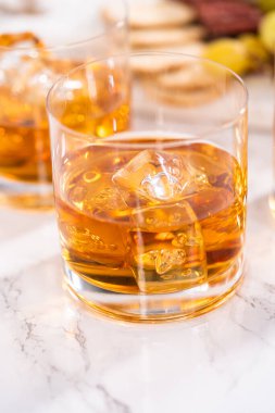 Buzlu viski, viski bardağında, beyaz mermer yüzeyde..