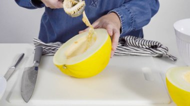 Adım adım. Beyaz kesme tahtasında kaygan altın çiğ taneli kavun.