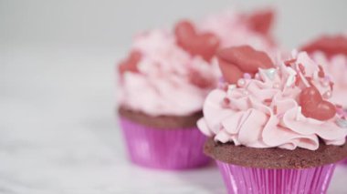 Krem peynirli kırmızı kadife kekler ve kalp ve öpücük şeklinde kırmızı çikolatalarla süslemeler..