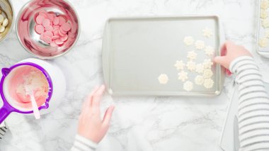 Düz yatıyordu. Adım adım. Çikolatalı kar tanelerini plastik çikolata kalıbından kurabiye tepsisine atmak..