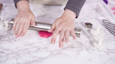 Adım adım. Pembe fondantımızı mermer tezgahta yuvarlıyoruz..