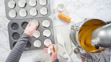 Düz yatıyordu. Balkabağı aromalı kek hamuru. Hamur hamuru kepçesiyle kapkek tepsisine dolgu malzemesi..