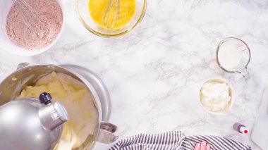 Düz yatıyordu. Adım adım. Kırmızı kadife kekler pişirmek için mutfak mikserinin malzemelerini karıştırıyorum..