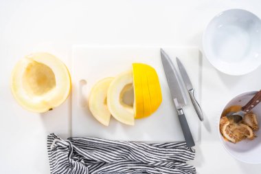 Düz yatıyordu. Beyaz kesme tahtasında kaygan altın çiğ taneli kavun.