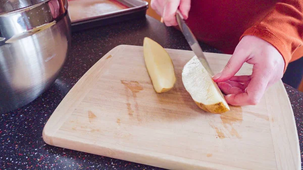 Preparing potato wedges on baking sheet in oven.