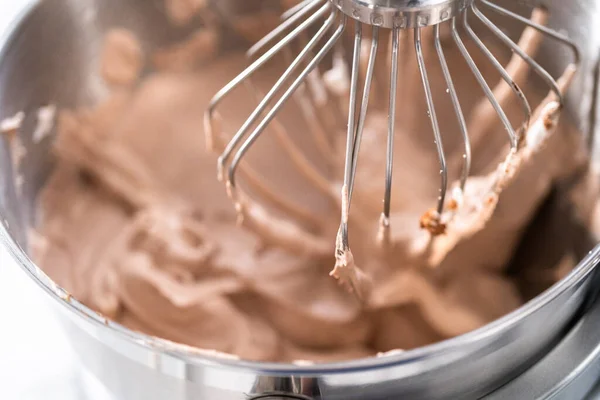 Mixing ingredients in a standing kitchen mixer to make homemade chocolate ice cream.