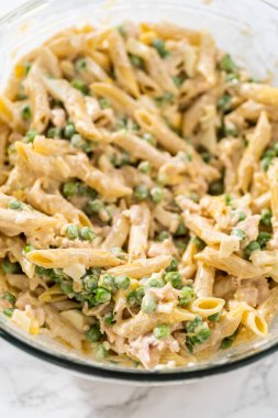 Makarna salatasını tavukla karıştırmak için büyük bardakta malzemeler karıştırıyorum..