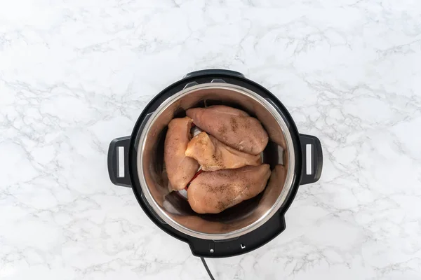 Flat lay. Shredded chicken in a pressure cooker. Cooking chicken breasts in a pressure cooker.