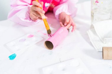 Tuvalet kağıdından tek boynuzlu at yapan küçük bir kız..