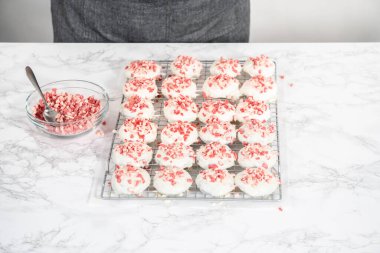 Naneli beyaz çikolatalı kurabiyeler hazırlamak için eritilmiş beyaz çikolataya çikolatalı kurabiyeler batırmak..