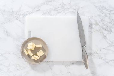 Düz yatıyordu. Beyaz bir kesme tahtasının üzerinde tuzsuz tereyağı dilimlemek.