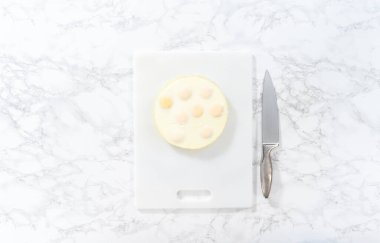 Düz yatıyordu. Beyaz bir kesme tahtasının üzerinde haşlanmış yumurta kesiyor..