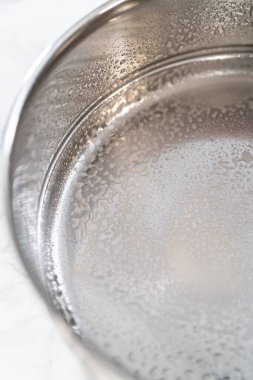 Yağlı düdüklü tencereye, kabuksuz haşlanmış yumurta pişirmek için sprey yağı eklenir..