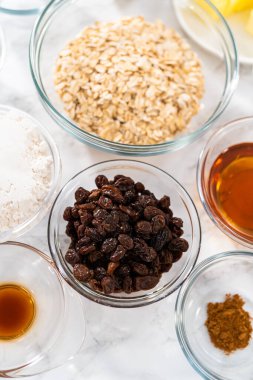 Yumuşak yulaf ezmesi üzümlü cevizli kurabiye pişirmek için cam karışımında ölçülmüş malzemeler..