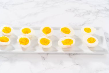 Beyaz servis tabağında dilimlenmiş haşlanmış yumurta..