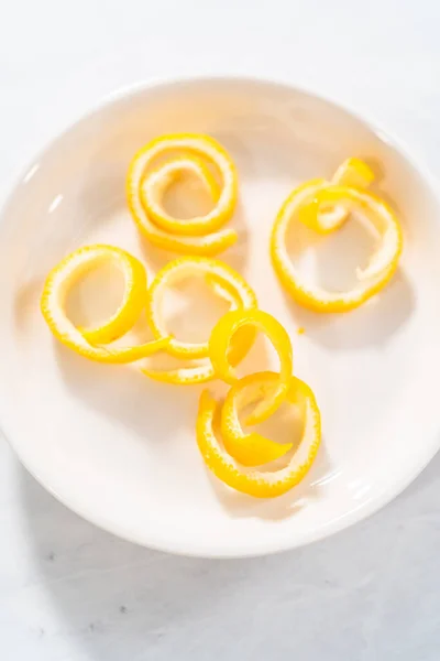 カクテルを飾るために有機レモンからレモンの渦巻きを準備します — ストック写真