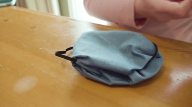 Koronavirüs salgını için dikiş makinesiyle pamuk yüz maskesi dikiyorum..