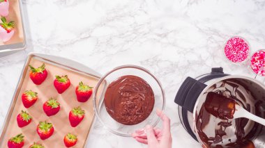 Düz yatıyordu. Adım adım. Erimiş çikolataya organik çilek batırmak..