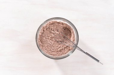 Düz yatıyordu. Çikolatalı kekle çikolatalı keki karıştırmak için bardaktaki malzemeleri karıştırıyorum..