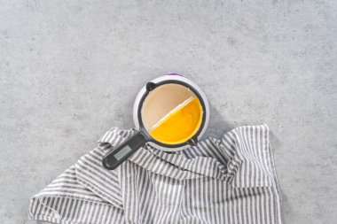 Flat lay. Melting color chocolate chips in a candy melting pot to make Easter chocolate-covered pretzel bunnies and ducklings.